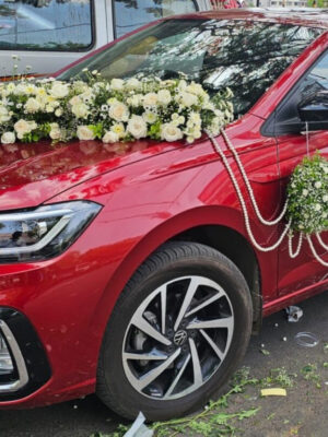 Red premium wedding car decoration with fresh white flowers and elegant floral styling