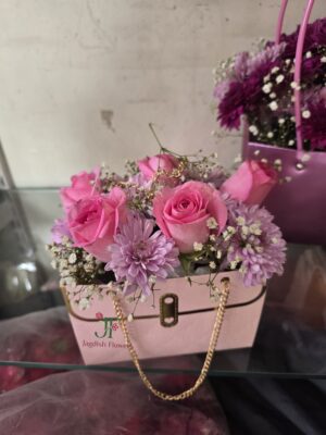 Trendy purse style bouquet with fresh roses and baby’s breath flowers