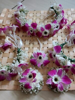 Handcrafted purple orchid, white Sevanti, and Gypsophila floral jewellery set with necklace, earrings, maang tikka, bracelet, and hair accessories for Haldi and Mehndi in Rajkot